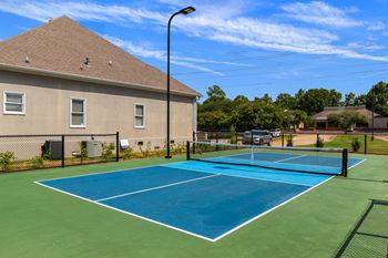 A tennis court with a blue surface and white lines.